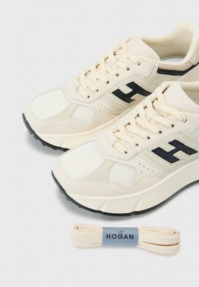 Crème-kleurige sneakers met mesh en suède materialen, voorzien van een zwart logo, gestructureerde accenten en platte crème veters.