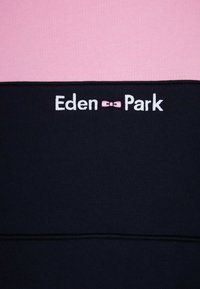 Sweatshirt en coton avec des rayures horizontales rose et marine, avec le logo "Eden Park" brodé en blanc sur la section marine.