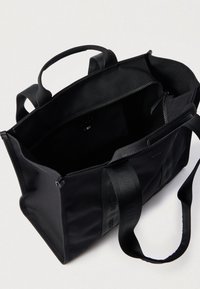Μαύρη τσάντα ώμου από ύφασμα με διπλές λαβές και κλείσιμο με φερμουάρ. Το εσωτερικό διαθέτει τσέπη με φερμουάρ και πολλαπλές θήκες για οργάνωση.