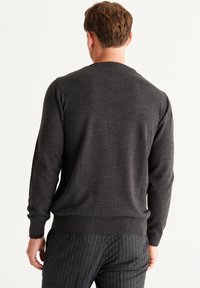 Dunkelgrauer Pullover für Herren, Rundhalsausschnitt, aus weichem Stoff. Gerippte Bündchen und Saum, einfaches Design mit einer fein strukturierten Oberfläche.