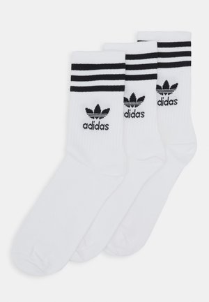 Calcetines de algodón blancos con rayas negras, con un logo de Adidas en el puño. Juego de tres pares, longitud hasta la mitad de la pantorrilla, textura suave.