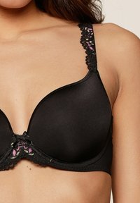 Soutien-gorge rembourré noir avec des accents en dentelle sur les bretelles et le centre, orné d'un motif floral dans des teintes de rose et de vert. Texture lisse et soutien par armatures.