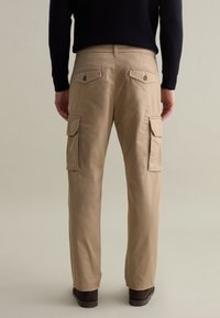 Beige Cargo-Hosen mit mehreren Seitentaschen, Gürtelschlaufen und geradem Bein. Aus leichtem Stoff mit glatter Textur gefertigt.