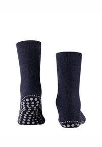 Tengerészkék zokni texturált kötött felülettel, fehér, csúszásgátló pöttyös mintával a talpán a jobb tapadás érdekében.