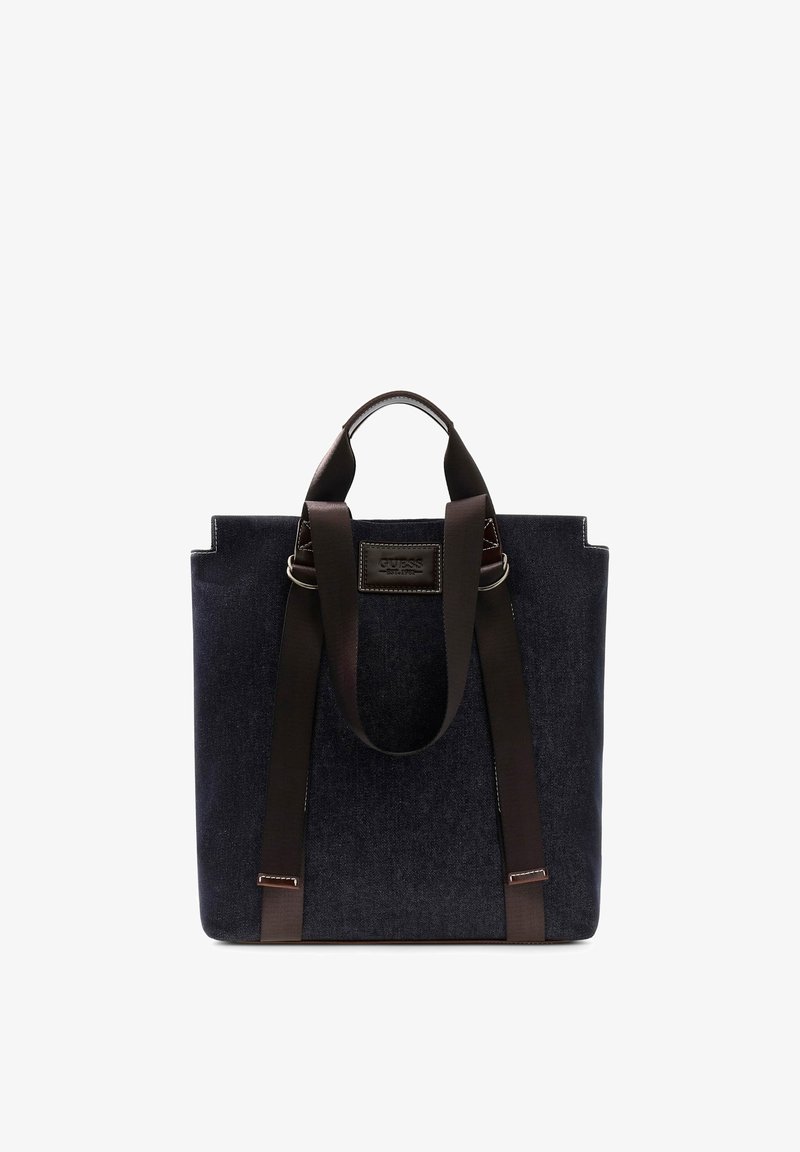 Sac cabas rectangulaire bleu foncé avec deux longues anses marron et une petite poignée de transport, avec une étiquette de marque cousue à l'avant.