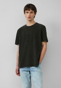 Dunkelgraues, kurzärmeliges T-Shirt mit Rundhalsausschnitt, das aus einem leicht strukturierten Stoff gefertigt ist und eine entspannte Passform bietet. Lässiges Gesamtdesign.