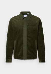 Veste en velours côtelé vert foncé avec col, boutons-pression à l'avant, poches latérales et broderie subtile sur la poitrine sur fond uni.
