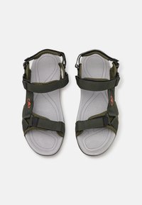 Green fabric sandals with adjustable straps, grey textured soles, and orange branding. Features contoured footbed for comfort.