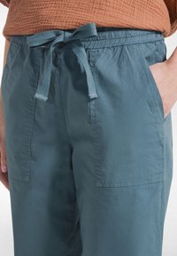 Ljusblå, lätta byxor med knytbart midjeband, sidfickor och en mjuk textur. Perfekta för vardagsbruk.