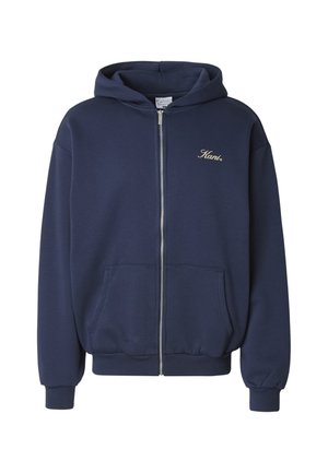 Navyblå hættejakke med lynlås lavet af blødt bomuldsblandingstof. Har en kængurulomme, ribstrikkede manchetter og et guld broderet logo på brystet.