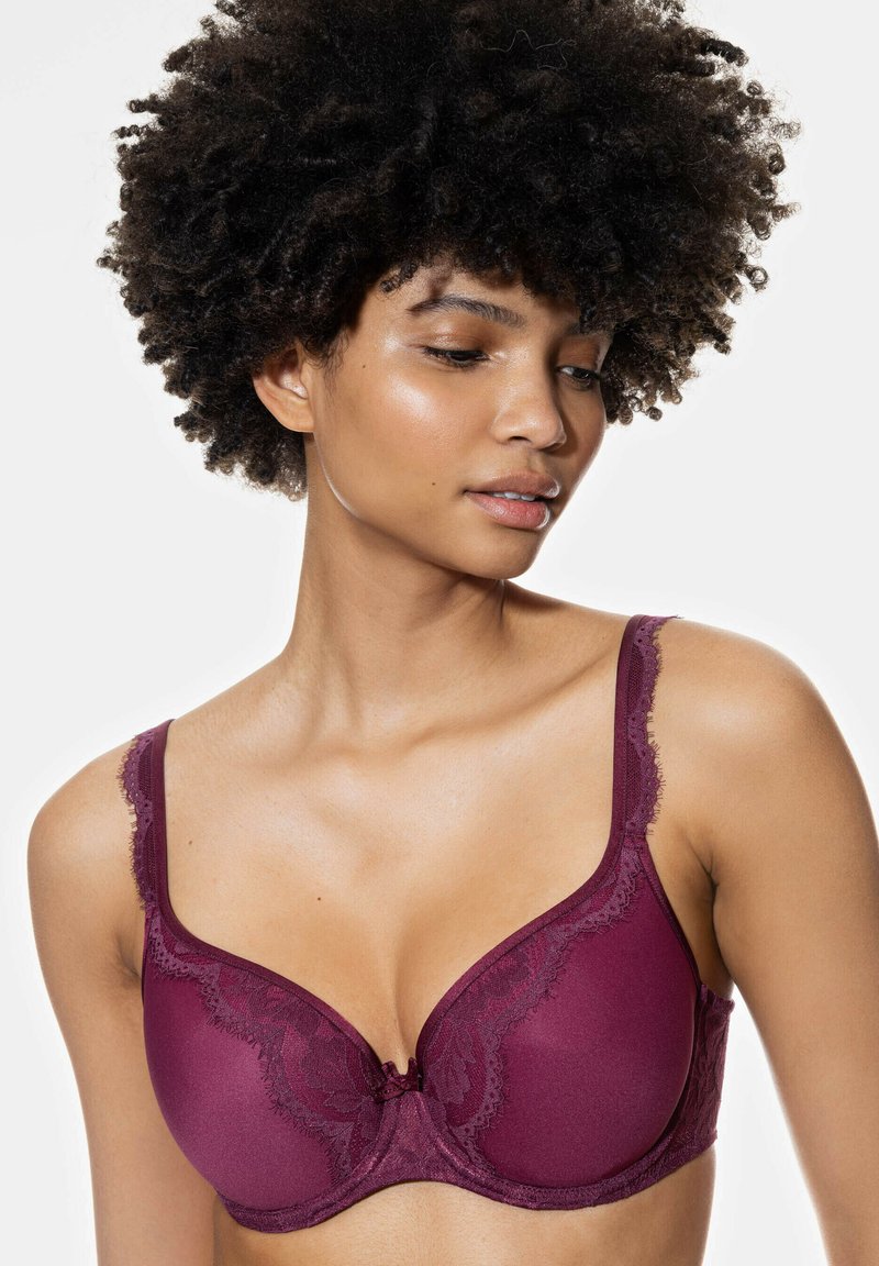 Burgundininen rintaliivi pitsikoristeluilla, sileillä kuppiosilla, säädettävillä olkaimilla ja koristeellinen nauha keskellä. Pehmeä tekstiili ja rakenteellinen muotoilu.