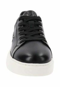 Zapatilla de cuero negro con una textura suave, suela de goma blanca y seis cordones. Presenta un logo en la lengüeta para la marca.