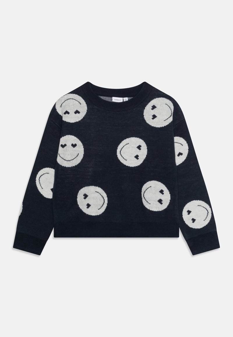 Pull bleu marine avec des visages souriants blancs, certains avec des yeux en forme de cœur, éparpillés sur le devant et les manches.