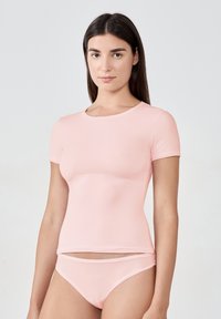 Jasnoróżowa bluzka z krótkim rękawem, wykonana z gładkiego, elastycznego materiału, w zestawieniu z pasującymi majtkami w stylu bikini, charakteryzującymi się prostymi liniami i minimalistycznym designem.