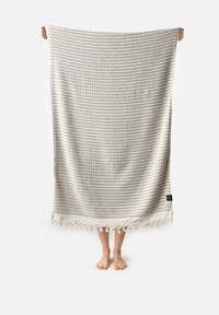 Kudottu tekstiilihuopa, jossa on vaaleanharmaa kuvio, fringed-reunat ja tekstuuri pinta. Materiaali on pehmeä ja kevyt.