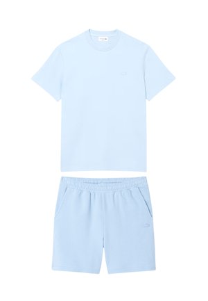 Camiseta de manga corta azul claro y pantalones cortos a juego con cintura elástica y bolsillos, colocados planos sobre un fondo blanco.