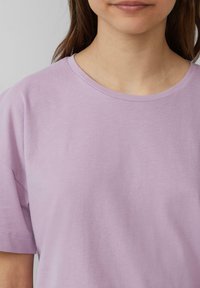 Lila katoen t-shirt met een ronde halslijn, korte mouwen en een zachte textuur. De stof lijkt lichtgewicht en comfortabel.