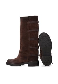 Hnědé kozačky z broušené kůže sahající ke kolenům s elastickými bočními vsadkami, nízkým podpatkem a protiskluzovou pryžovou podrážkou. Hladký svršek s jemnými švy.