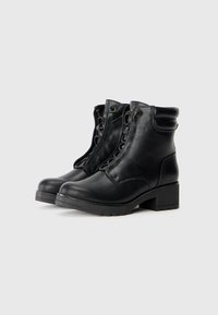 Bottines noires en cuir avec un bout arrondi, un laçage à l'avant et un talon épais et robuste. Comprend des accents de couture et un col rembourré.