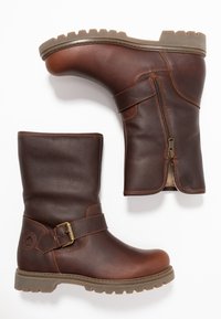 Braune Lederstiefel mit strukturiertem Finish, Knöchelhöhe, seitlichem Reißverschluss, Schnallendetail und rutschfester Laufsohle.