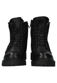 Paire de bottes en cuir noir à lacets avec semelles en caoutchouc épaisses et finition texturée, vues de face.