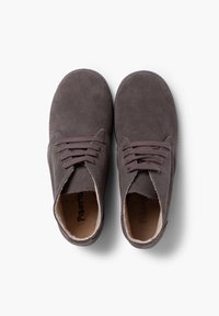 Chaussures en daim marron avec une texture douce, bout arrondi et design à six œillets avec lacets. L'intérieur présente un contraste de couleur claire.