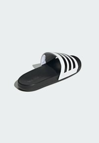 Sort slidesandal med hvidt tre-stribe design, åben tå, gummisål og tekstureret overflade. Branding synlig på sålen.