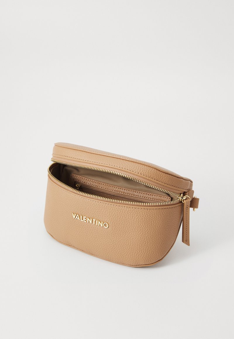 Neceser de cuero beige con cremallera dorada, forma redonda, textura con relieve y un logo dorado "VALENTINO" en la parte frontal.