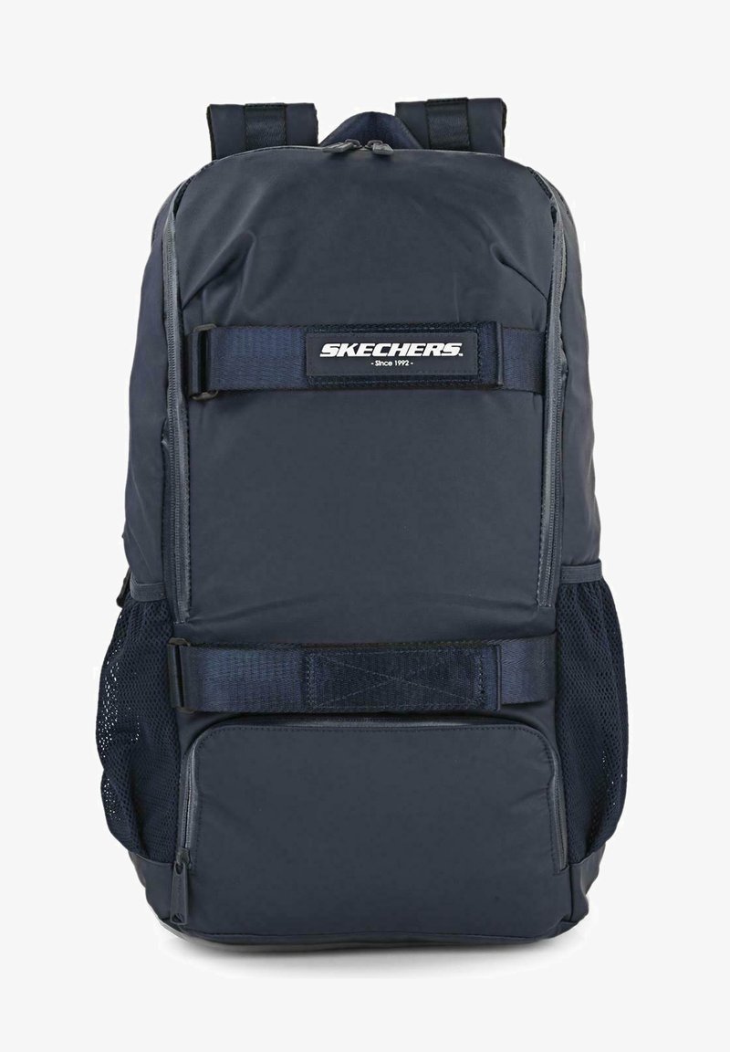 Mochila azul marino con un acabado suave y texturizado, que cuenta con correas ajustables, bolsillos laterales de malla y un parche con el logo en la parte frontal.