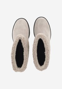 Bottes en suède beige clair avec une semelle en caoutchouc noir, dotées d'une doublure intérieure douce et duveteuse et d'un bord festonné en haut.