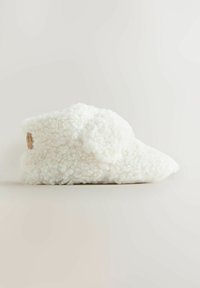 Vit, fluffig toffel gjord av strukturerad tyg, med en rundad form och lätt dekor på sidorna för extra detalj.