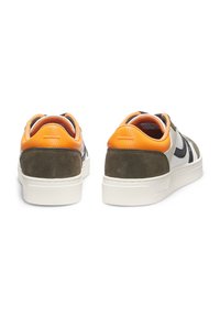Sneakers aus einer Kombination von olivgrünem Veloursleder und weißem Leder, mit einem orangefarbenen Fersenlasche und schwarzen Streifen an den Seiten.