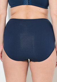 Mutande alta color blu navy realizzate in tessuto liscio. Presentano un design senza cuciture con una texture morbida, offrendo una copertura totale sul retro.