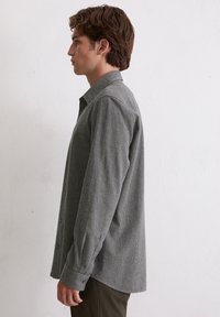 Grau-weiße karierte Langarmbluse mit Button-Down-Kragen, die eine lockere Passform und geknöpfte Manschetten aufweist.