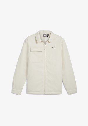 Krém színű dzseki, cipzáros elől, hegyes gallérral és hosszú ujjakkal. Egyzsebes kialakítás, fekete logóval az emlőrészen.