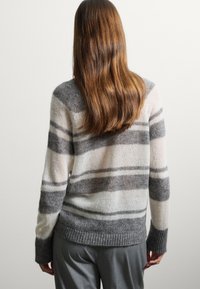 Strickpullover mit horizontalen Streifen in Grautönen und Creme, mit geripptem Saum und Bündchen, weicher Textur und lässiger Passform.