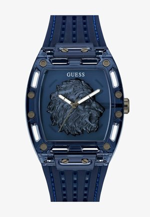 Montre-bracelet en plastique transparent bleu avec un relief de lion sur le cadran, aiguilles des heures et des minutes argentées, et un bracelet en caoutchouc texturé bleu.