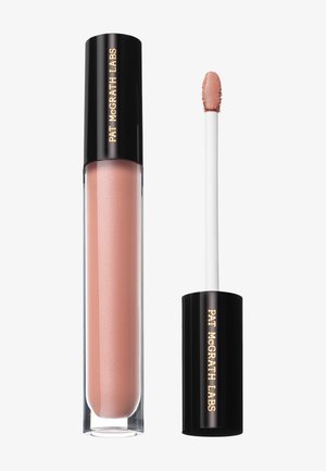 Lippenpflegestift mit schwarzem Deckel, beschriftet mit "Pat McGrath Labs", und einem Applikatorstab, der einen zarten nude-pinken Glanz an der Spitze zeigt.
