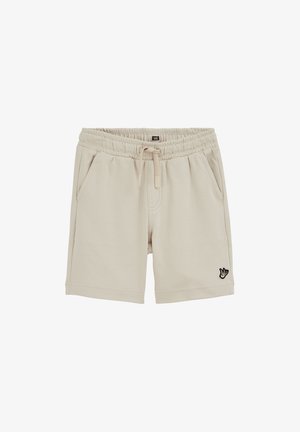 Short beige avec taille élastique, cordon de serrage, poches latérales et petit logo oiseau noir et blanc sur la jambe gauche.