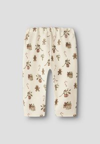 Legginsy w kolorze śmietankowym z świątecznym wzorem przedstawiającym piernikowe postacie, ozdoby, prezenty i cukrowe laski; miękki, elastyczny materiał.