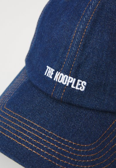 Džinsu cepure ar tumši zilu audumu, balti izšūti logo "THE KOOPLES", oranža dūriena detalizācija un izliekts malu dizains.