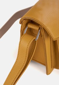 Borsa a tracolla gialla in pelle con una finitura testurizzata, caratterizzata da un design strutturato, una tracolla robusta con dettagli in metallo e una chiusura a pattina.