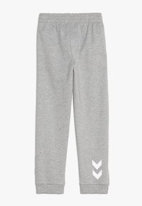 Grijze katoen joggingsbroek met een elastische tailleband, taps toelopende pijpen en een wit chevronpatroon aan de onderzijde aan de linkerkant.