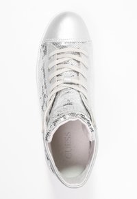 Stříbrné vysoké tenisky se zdobením z flitrů, hladkými kovovými akcenty a béžovými tkaničkami. Mají zaoblenou špičku a polstrovaný límec.