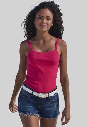 Aangepaste roze tanktop met dunne schouderbanden, gecombineerd met donkerdenim shorts met een rafelrand en een witte riem met een gouden gesp detail.