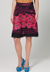 Gonna a fantasia floreale con fiori rosa su sfondo nero, con accenti di testo scritto a mano, completata da un orlo nero.