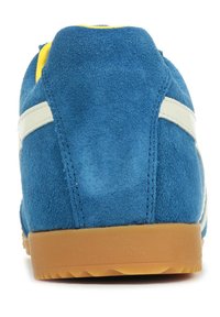 Sneaker blu in suede con strisce bianche, tacco rotondo e suola in gomma. Texture morbida con colletto imbottito e dettagli gialli a contrasto.