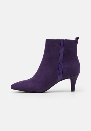 Bottine en daim violet avec un bout pointu, un petit talon kitten et un empiècement latéral élastique texturé pour un port facile.