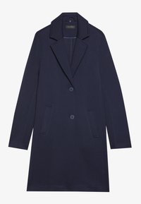 Cappotto lungo blu navale realizzato in tessuto liscio, con revers a punta, due tasche frontali e chiusura a due bottoni. Design minimalista con linee pulite.