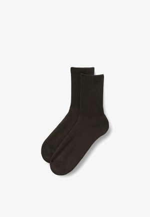 Paire de chaussettes unies marron foncé à bord-côte, étalées à plat sur un fond blanc.